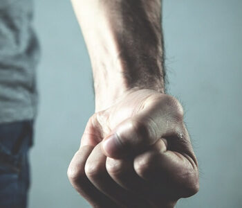 Close-up of a clenched fist symbolising aggression, relating to the discussion on testosterone and its impact on aggression.