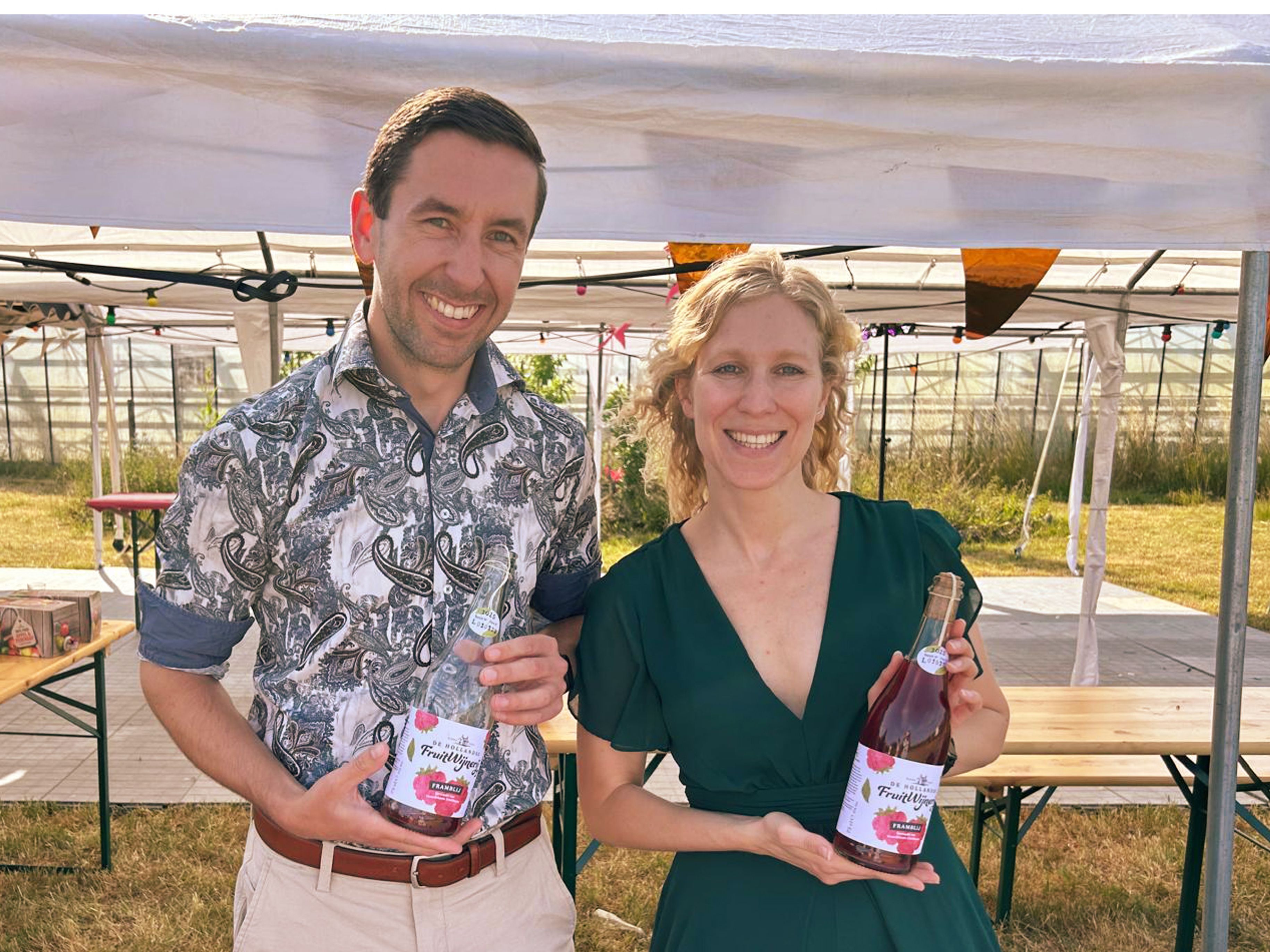 Matthijs en Leonie met een (een volle en een bijna lege) fles fruitwijn