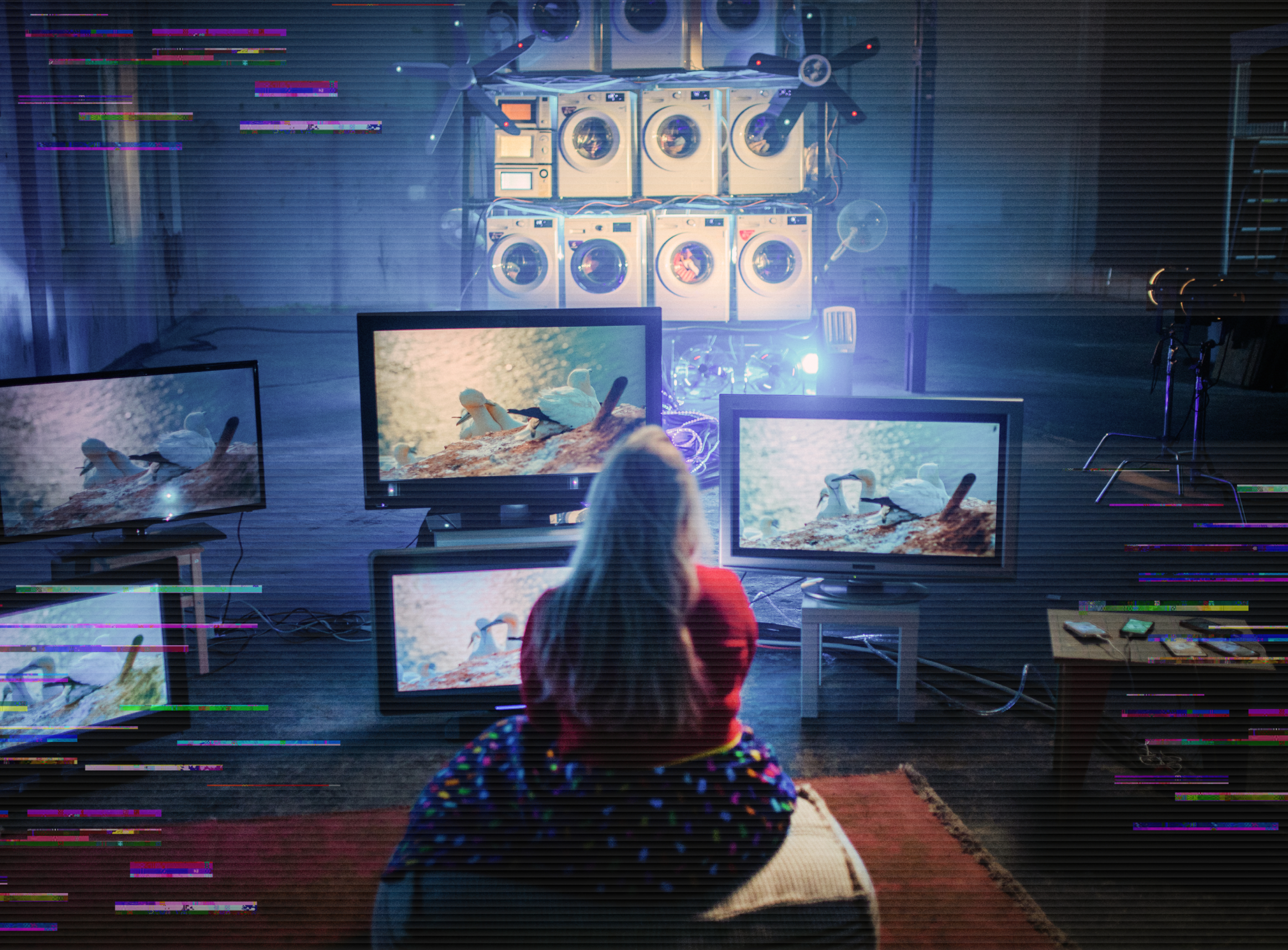 Vrouw achter een heleboel monitoren en wasmachines
