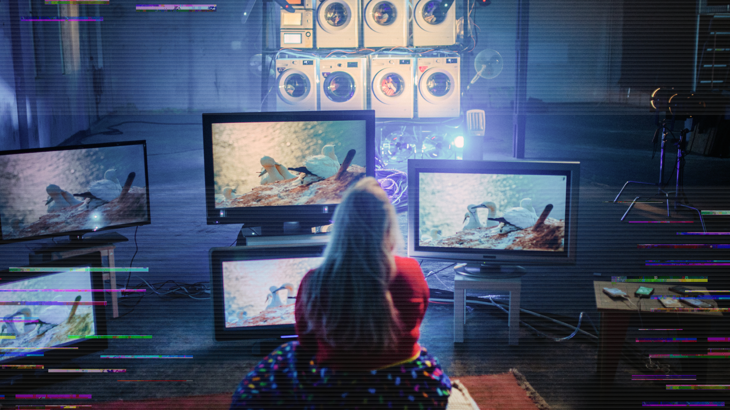 Vrouw achter een heleboel monitoren en wasmachines