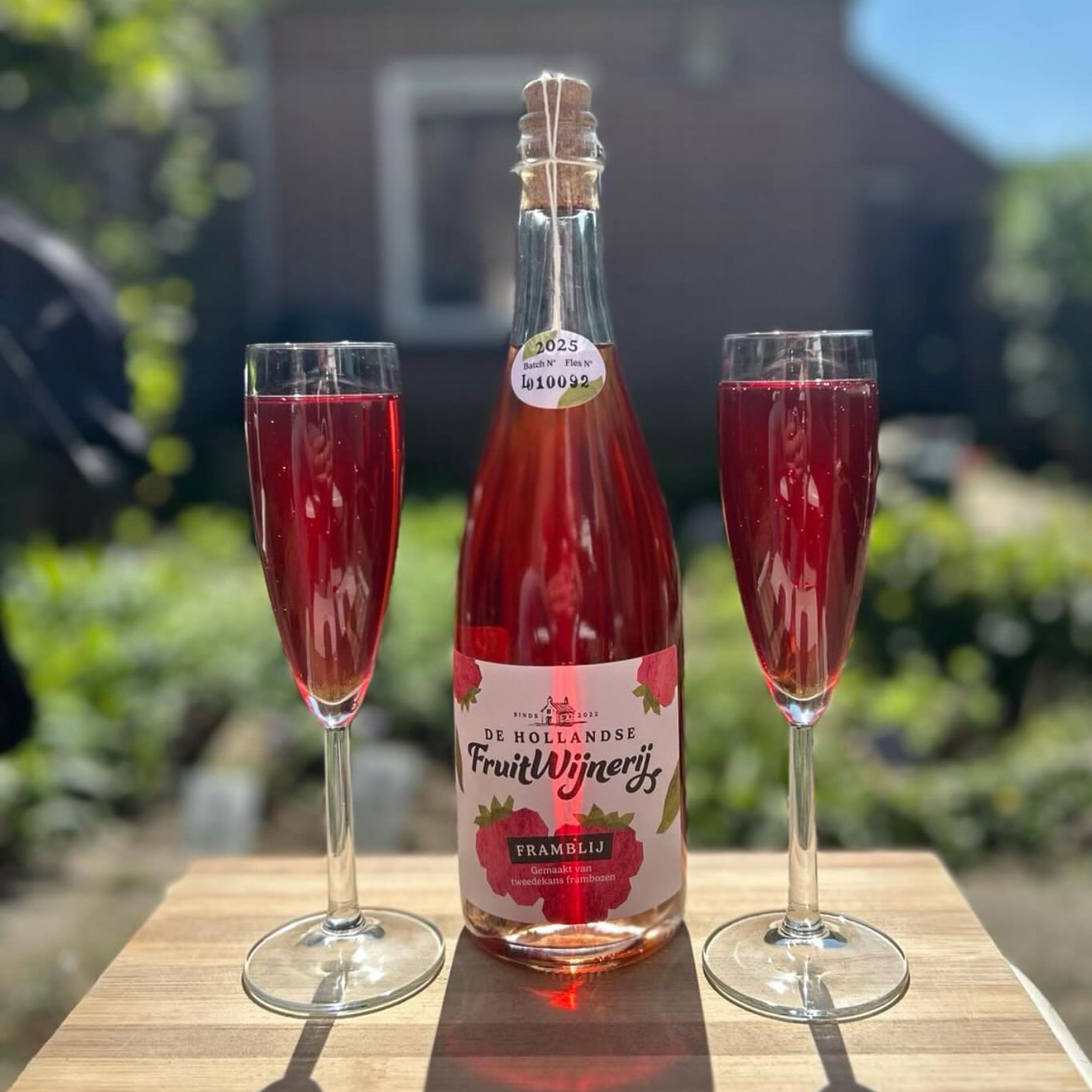 Fles fruitwijn en twee glazen