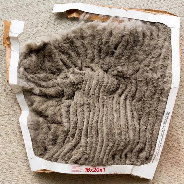 Used 16x20x1 air filter completely covered in gray dust