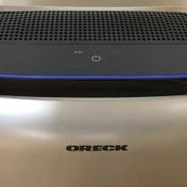 Oreck portable air purifier on a wood floor