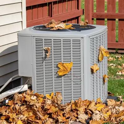 Outdoor air conditioning unit covered in fallen autumn leaves