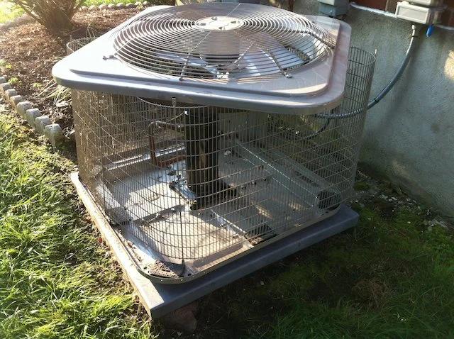 Outdoor air conditioning unit locked inside a metal security cage
