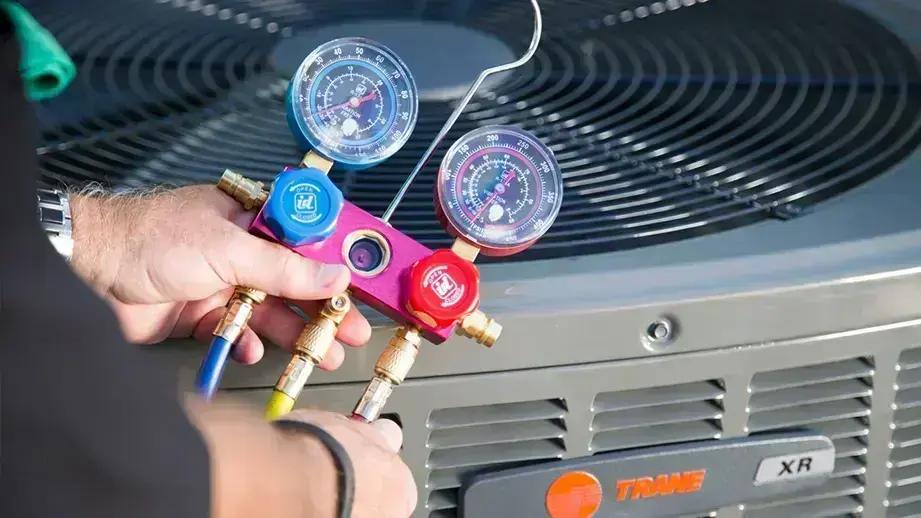 Refrigerant gauges connected to the top of an outdoor air conditioning unit