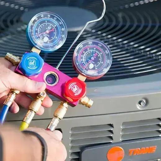 Refrigerant gauges connected to the top of an outdoor air conditioning unit