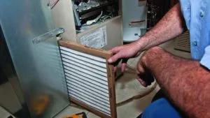 Man sliding a new air filter into a furnace