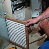 Man sliding a new air filter into a furnace