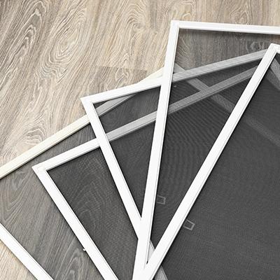 Stack of window screens on a wood floor