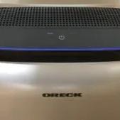 Oreck portable air purifier on a wood floor