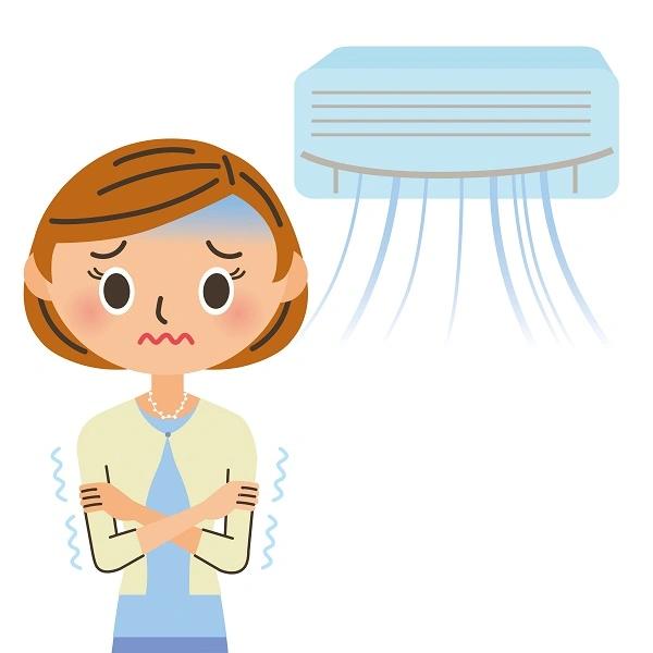 Cartoon of a shivering woman standing under a wall-mounted air conditioner