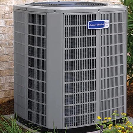 American Standard outdoor air conditioning unit beside a brick wall