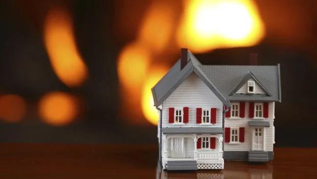 Model house in front of a blurred fire
