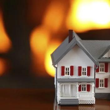 Model house in front of a blurred fire