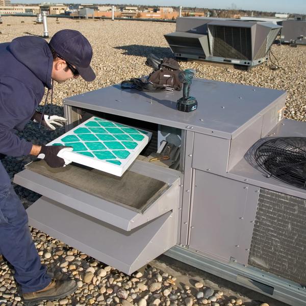 Technician replacing the filter in a rooftop HVAC unit