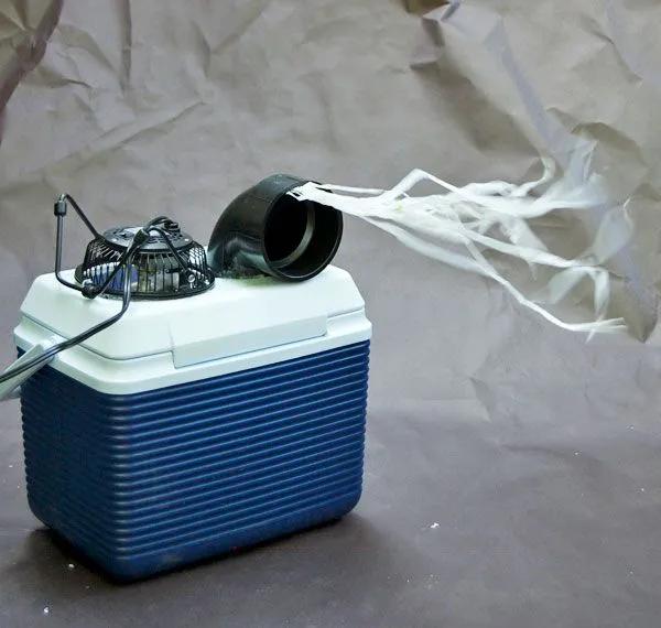 Homemade cooler-box air conditioner with a fan blowing streamers