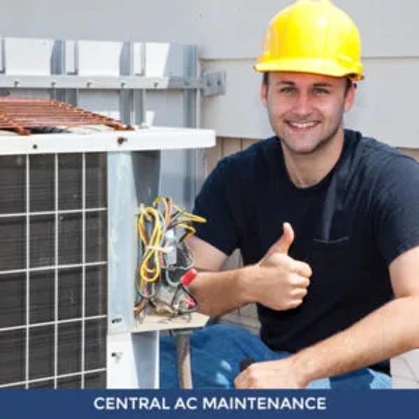 Smiling technician in a hard hat giving a thumbs up beside an outdoor unit, captioned "Central AC Maintenance"
