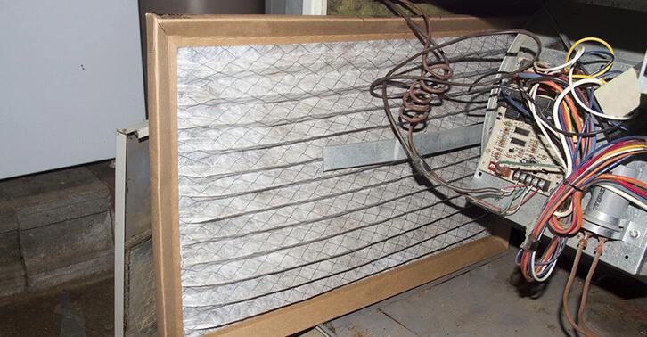Air filter installed inside a furnace with wiring visible