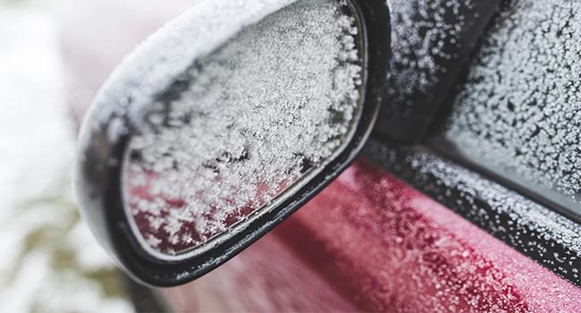 Car side mirror covered in frost