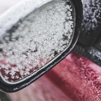 Car side mirror covered in frost