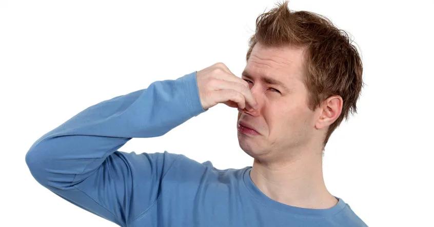 Man pinching his nose against a bad smell