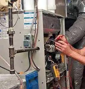 Technician servicing the burner assembly of a furnace
