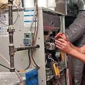 Technician servicing the burner assembly of a furnace