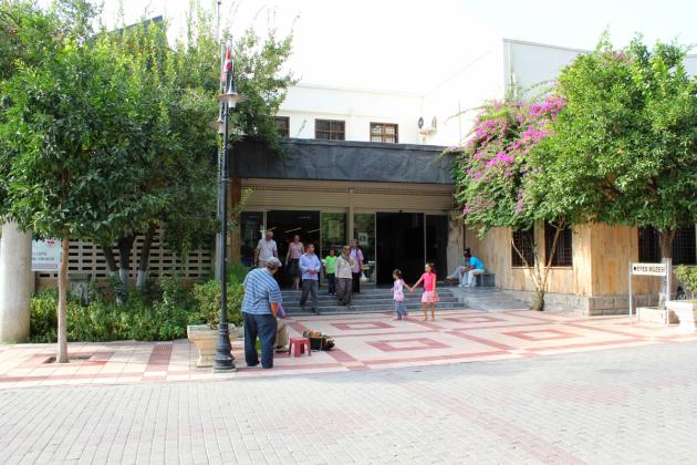The entrance building of the Ephesus Museum in Selçuk, with its 'Efes Müzesi' sign, a carved stone relief above the doorway, and visitors in the forecourt.