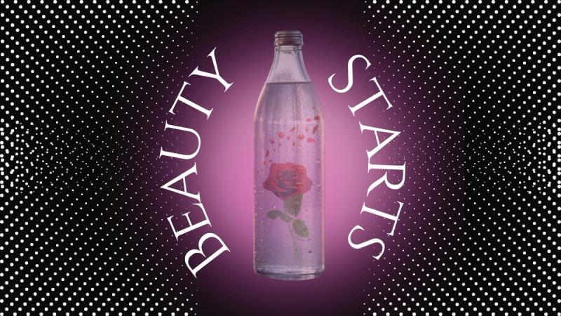 A glass bottle with the words Beauty Starts