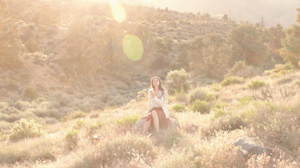 young woman sitting in a meadow