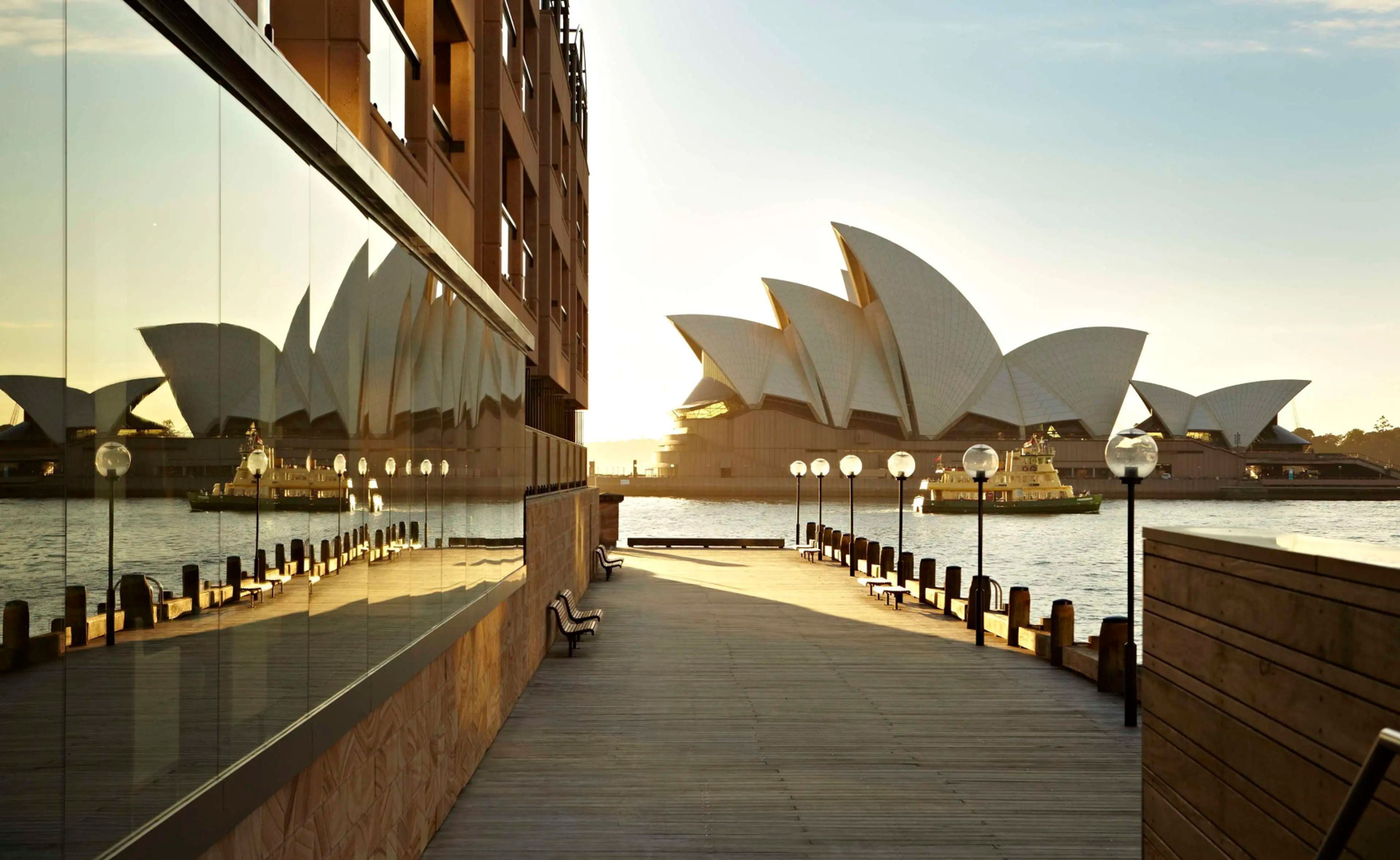 Boardwalk beside the Park Hyatt Sydney at sunrise, with the Sydney Opera House and a harbour ferry across the water