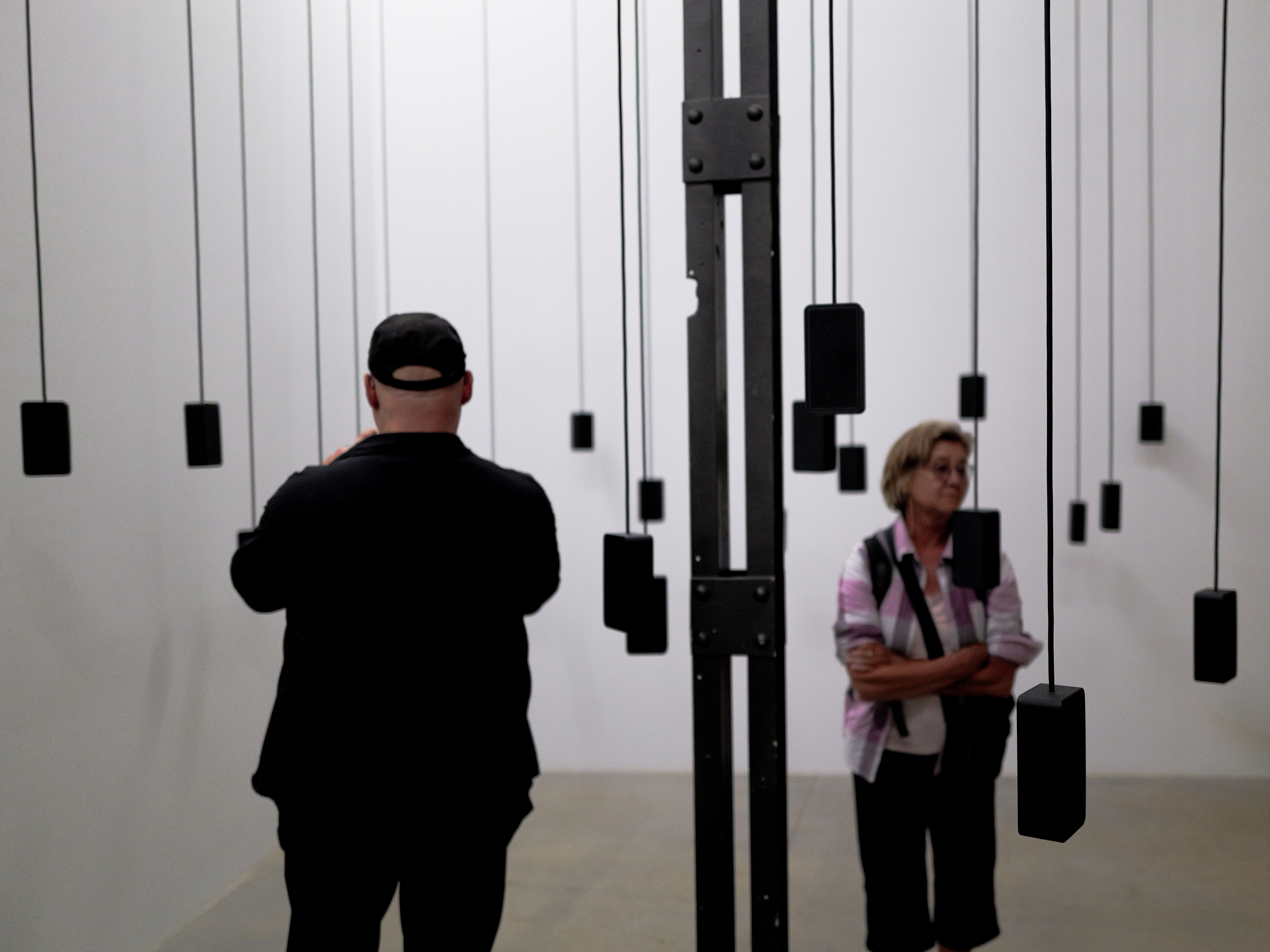 Visitors listening among suspended speakers at the 2026 Venice Biennale.