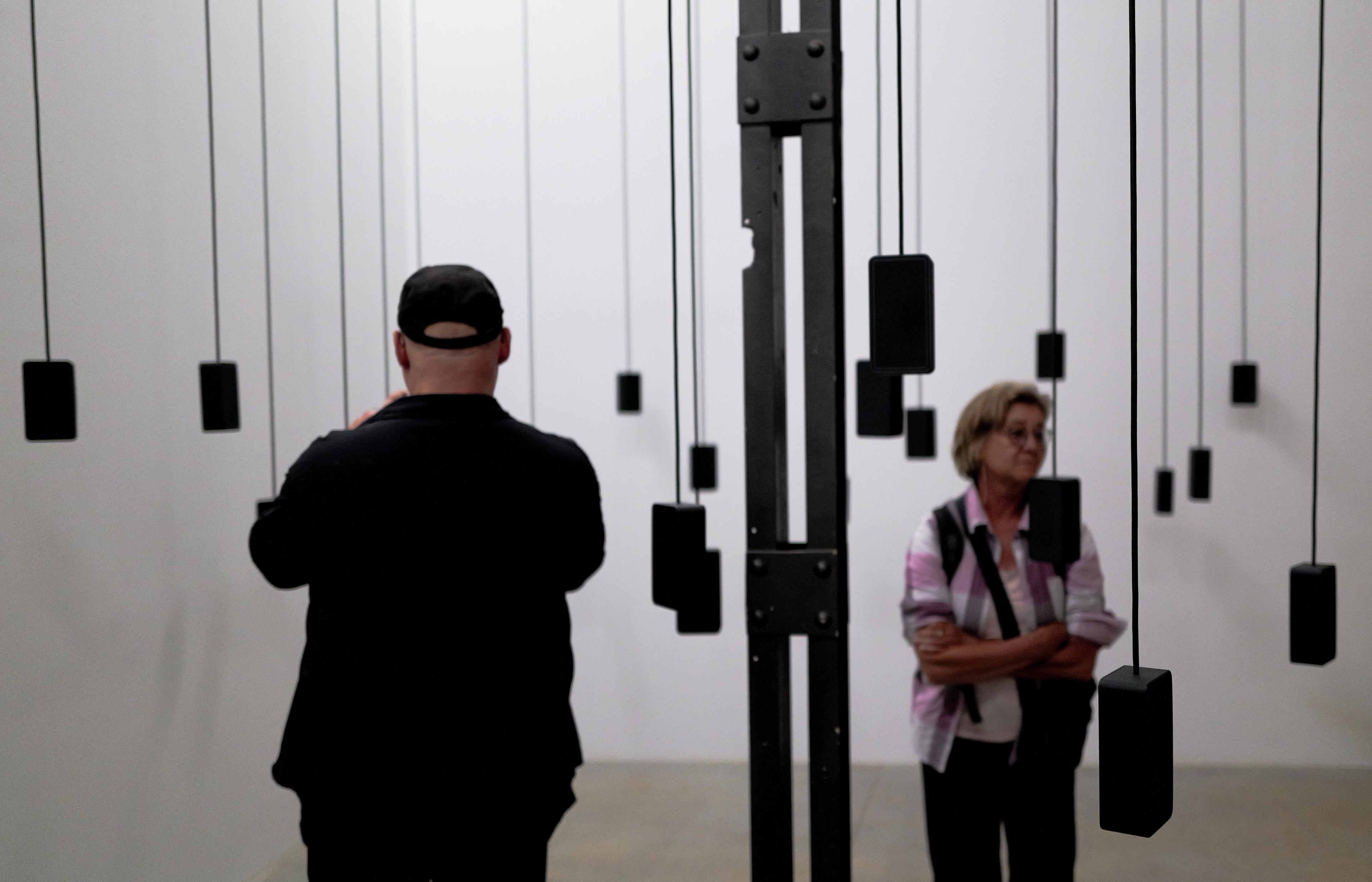 Visitors listening among suspended speakers at the 2026 Venice Biennale.