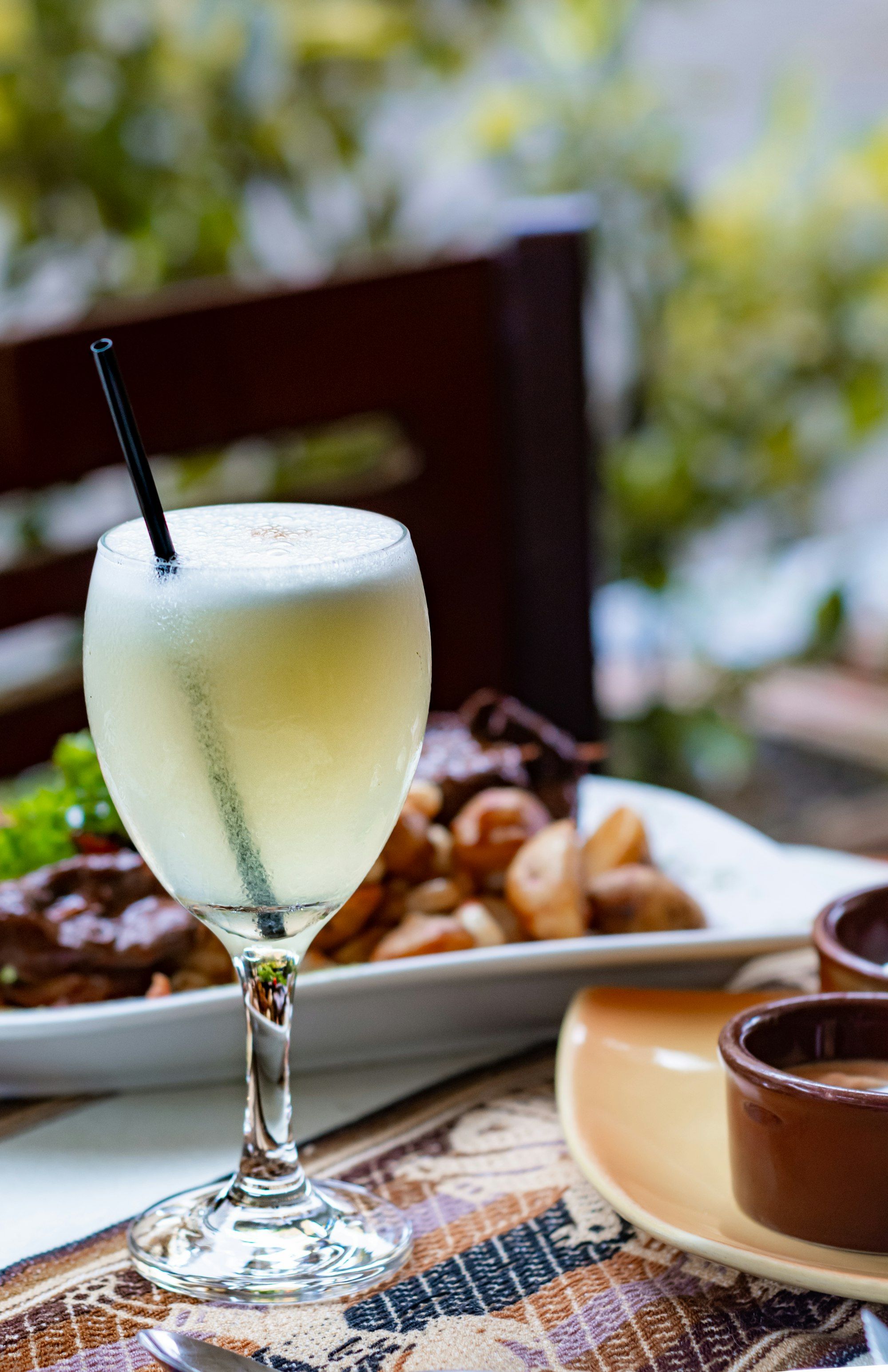 Pisco sour accanto a un piatto di chicharrón