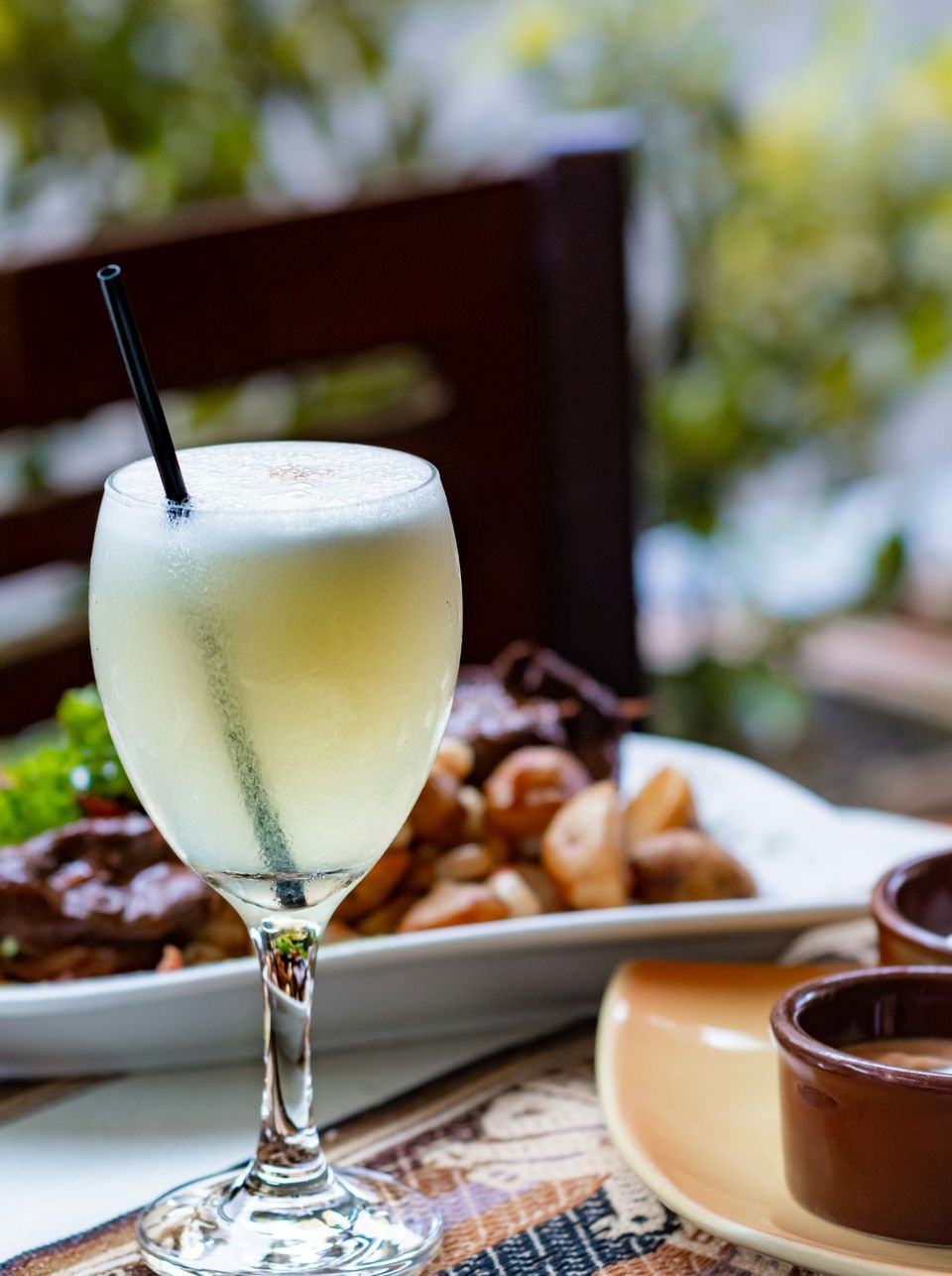 Pisco sour accanto a un piatto di chicharrón