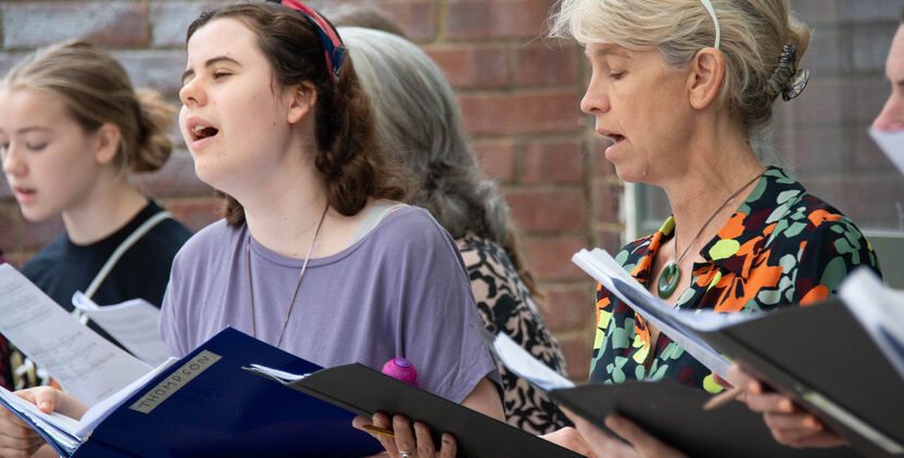 A choir of singers mid-rehearsal.