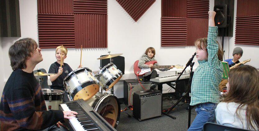 A rock band playing with electric guitars and drums.