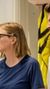 Marie Sneve Martinussen og Bjørnar Moxnes står foran en hvit vegg med en gul refleksvest,på byggeplassbesøk