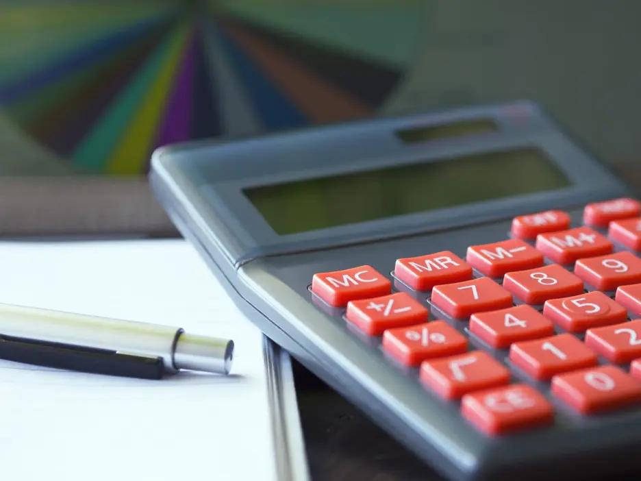 Traditional construction cost estimator using a basic calculator, representing the limitations of manual and formula-based home building cost methods