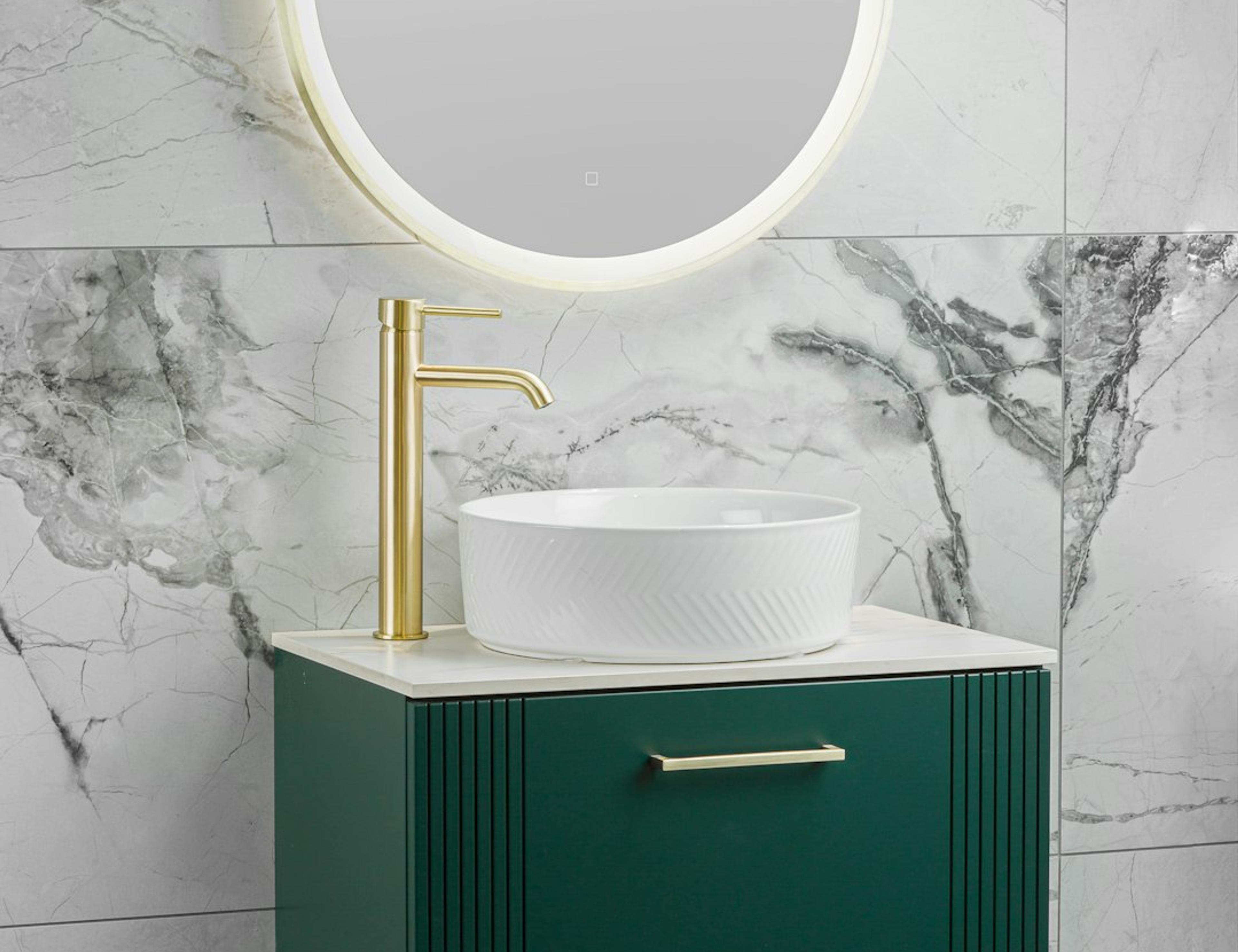 Emerald green floating vanity with round LED mirror against marble wall