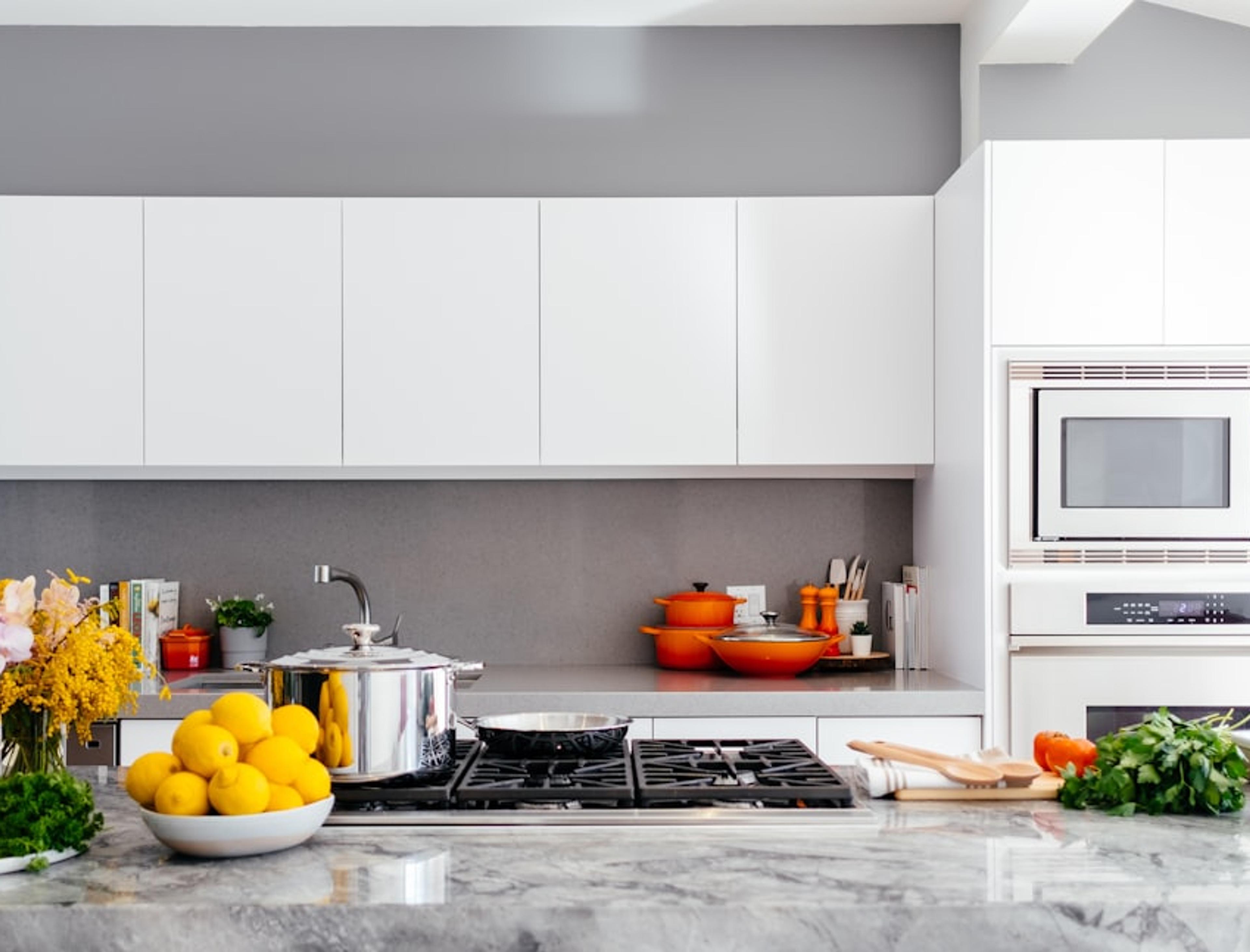 Modern white kitchen with marble countertop and backsplash