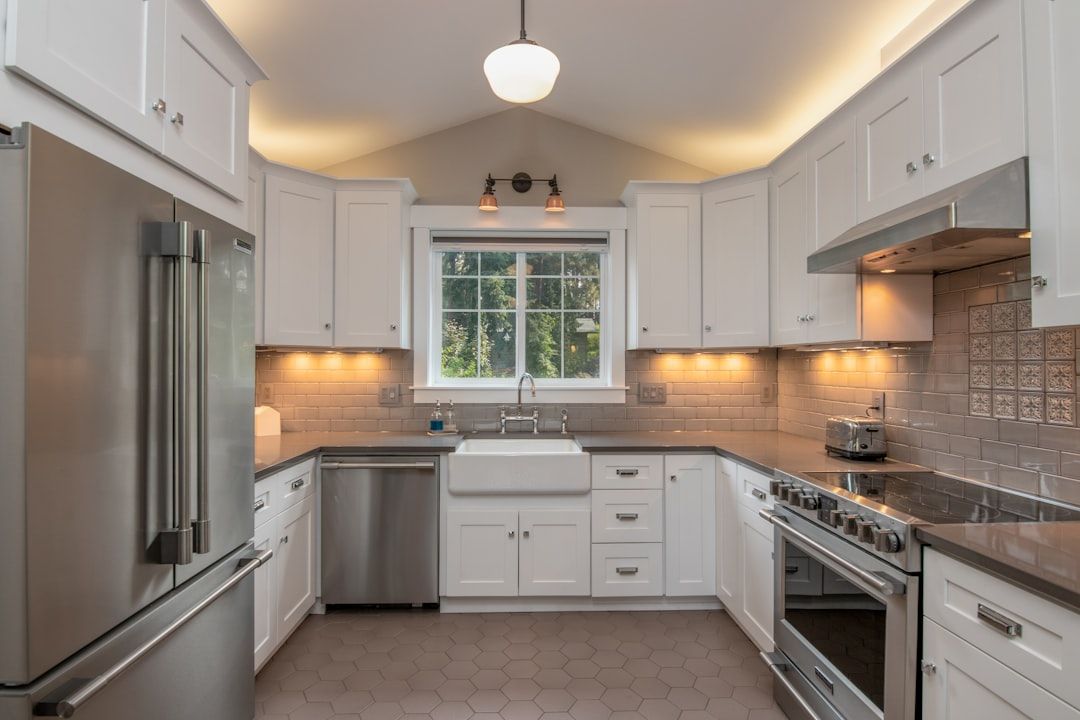 Classic white kitchen with farmhouse sink, stainless appliances, and arched ceiling