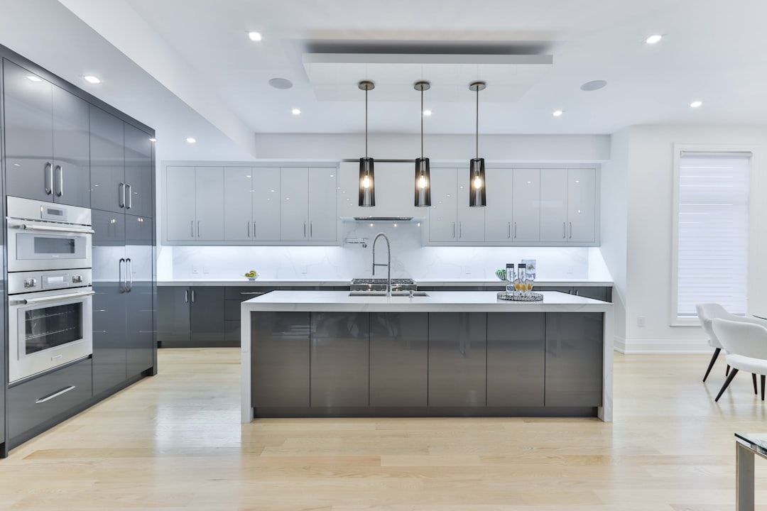 Large dark gray island with triple pendants in an open-plan kitchen