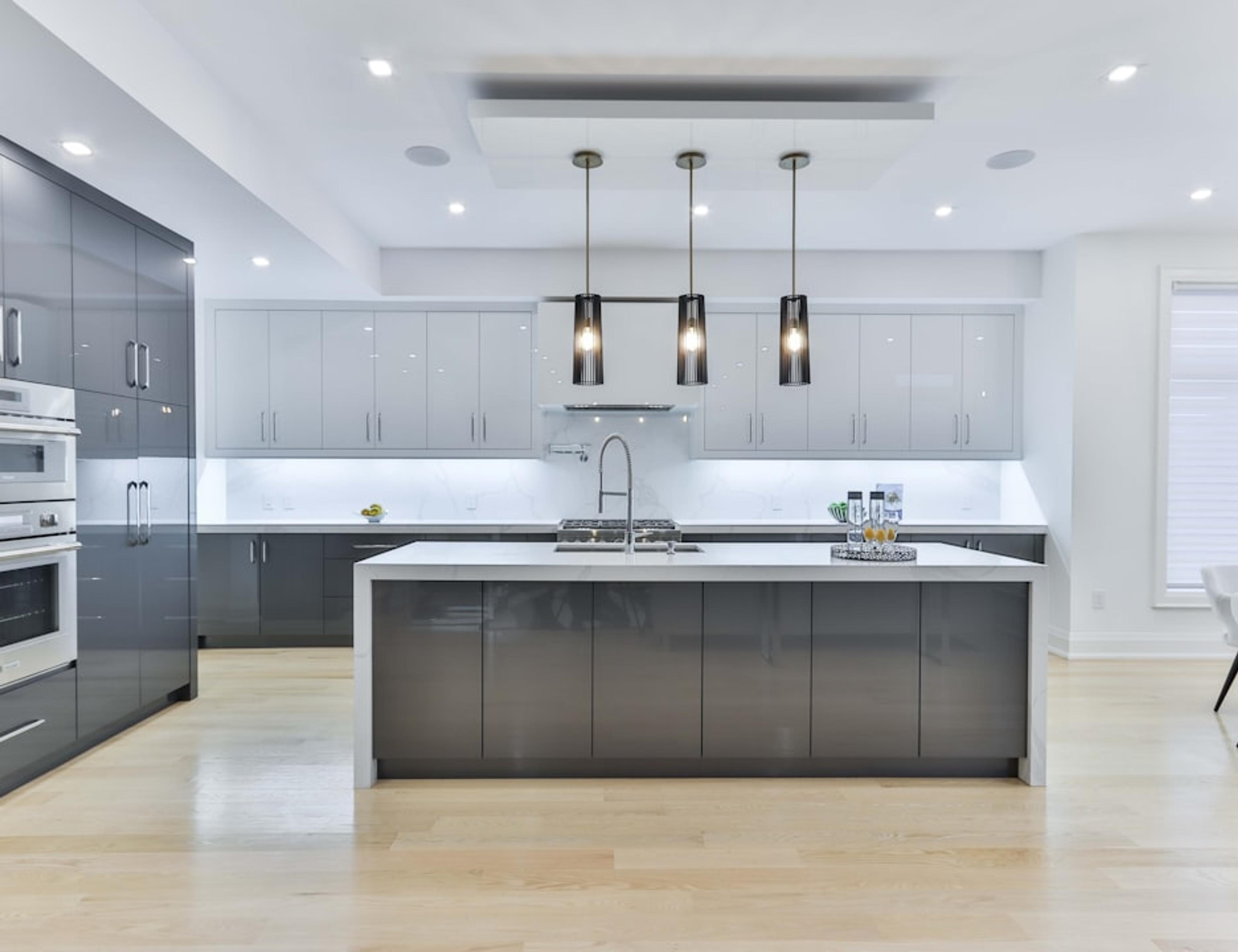 Large dark gray island with triple pendants in an open-plan kitchen