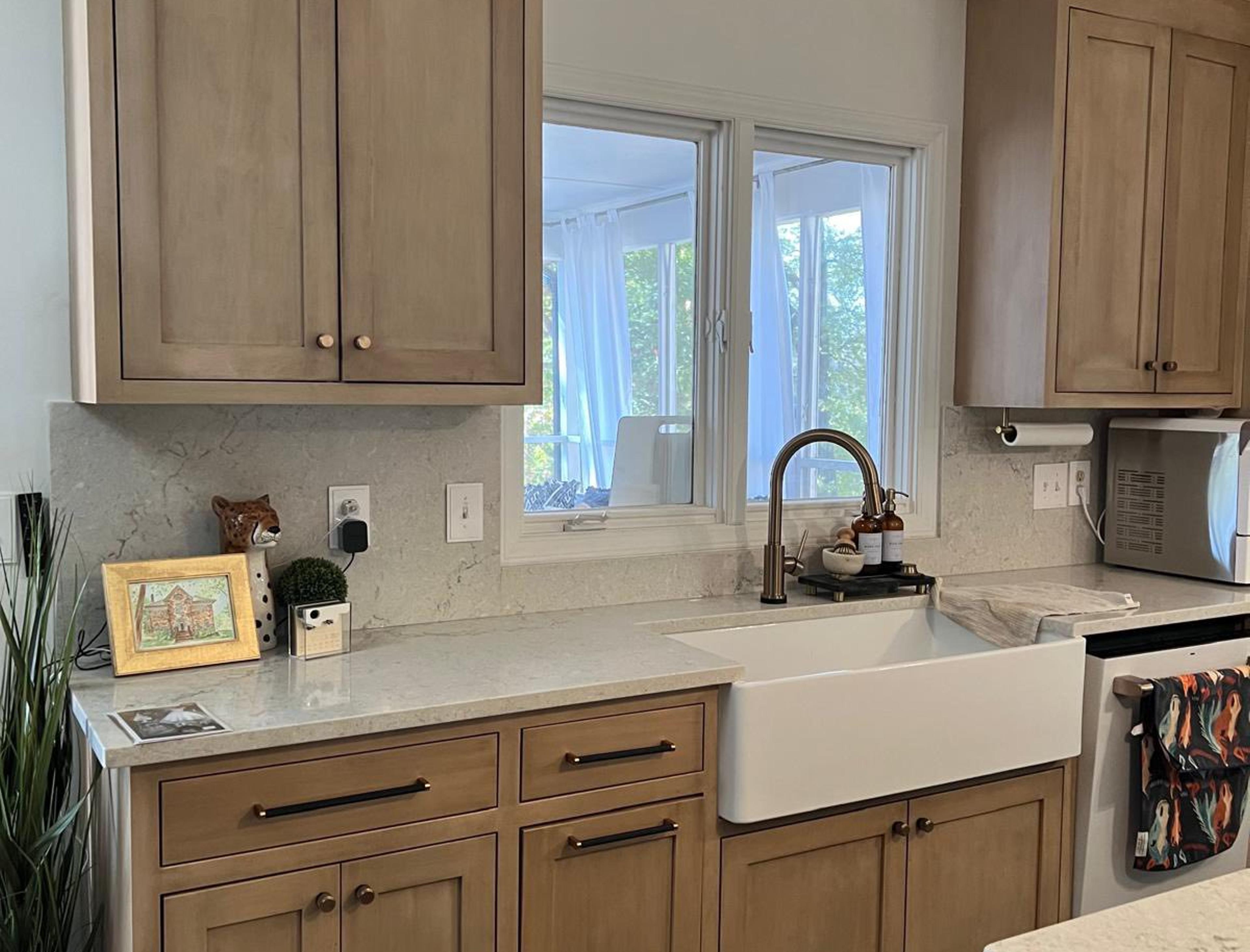 Natural wood shaker run with brass faucet, farmhouse sink and white quartz