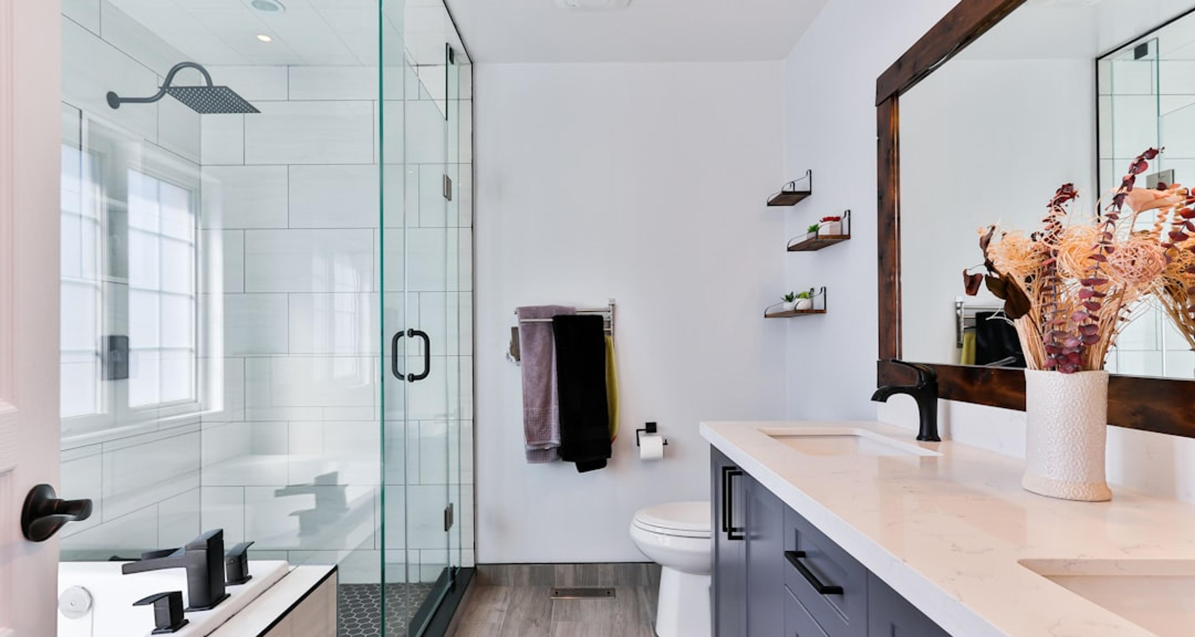 Compact bathroom with glass shower and dark vanity