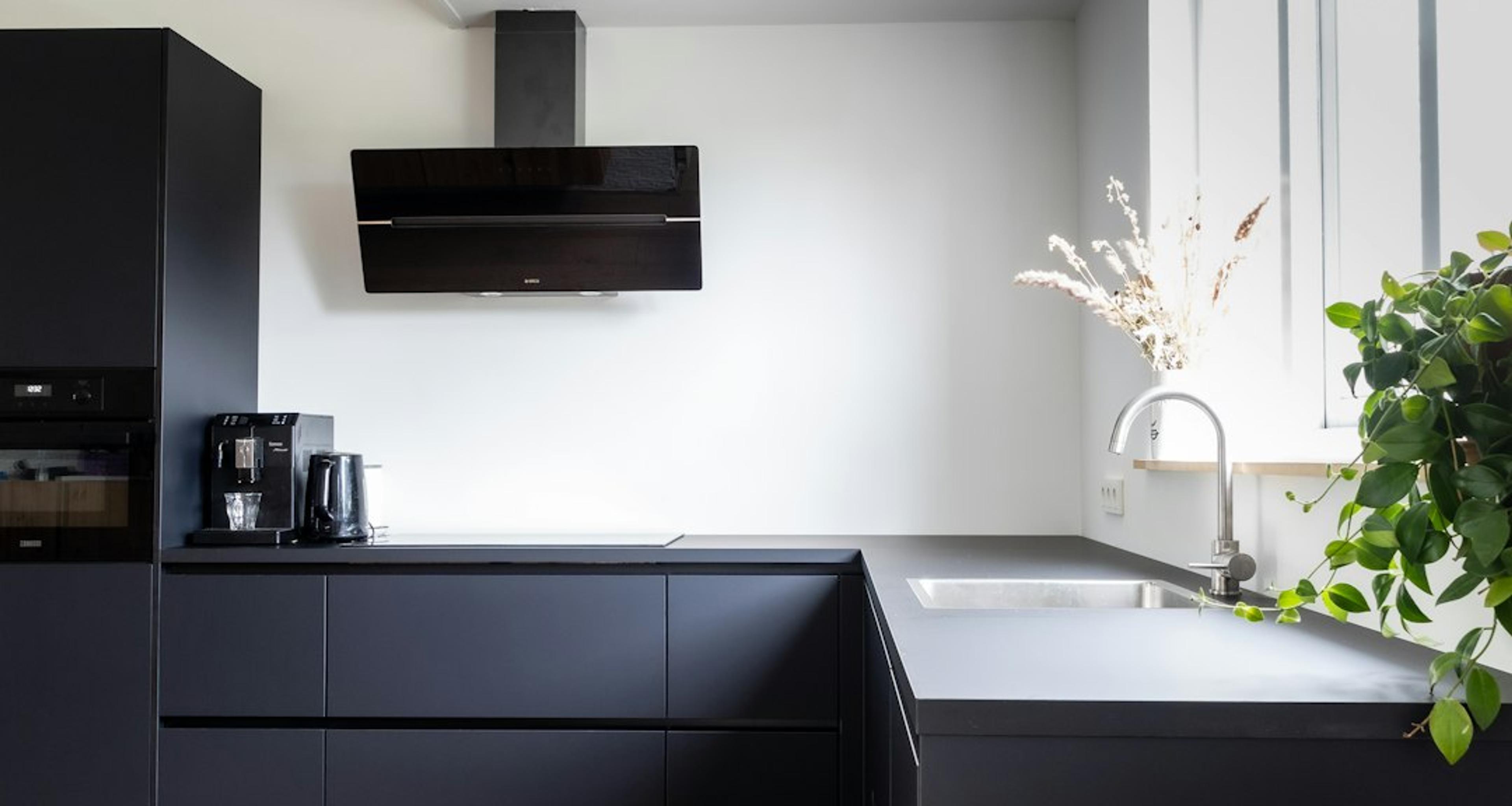 Matte black modern kitchen with warm wood flooring