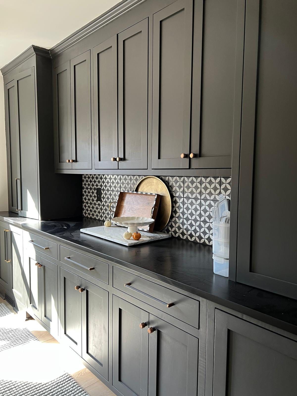 Graphite shaker cabinets with mosaic backsplash and dark countertops