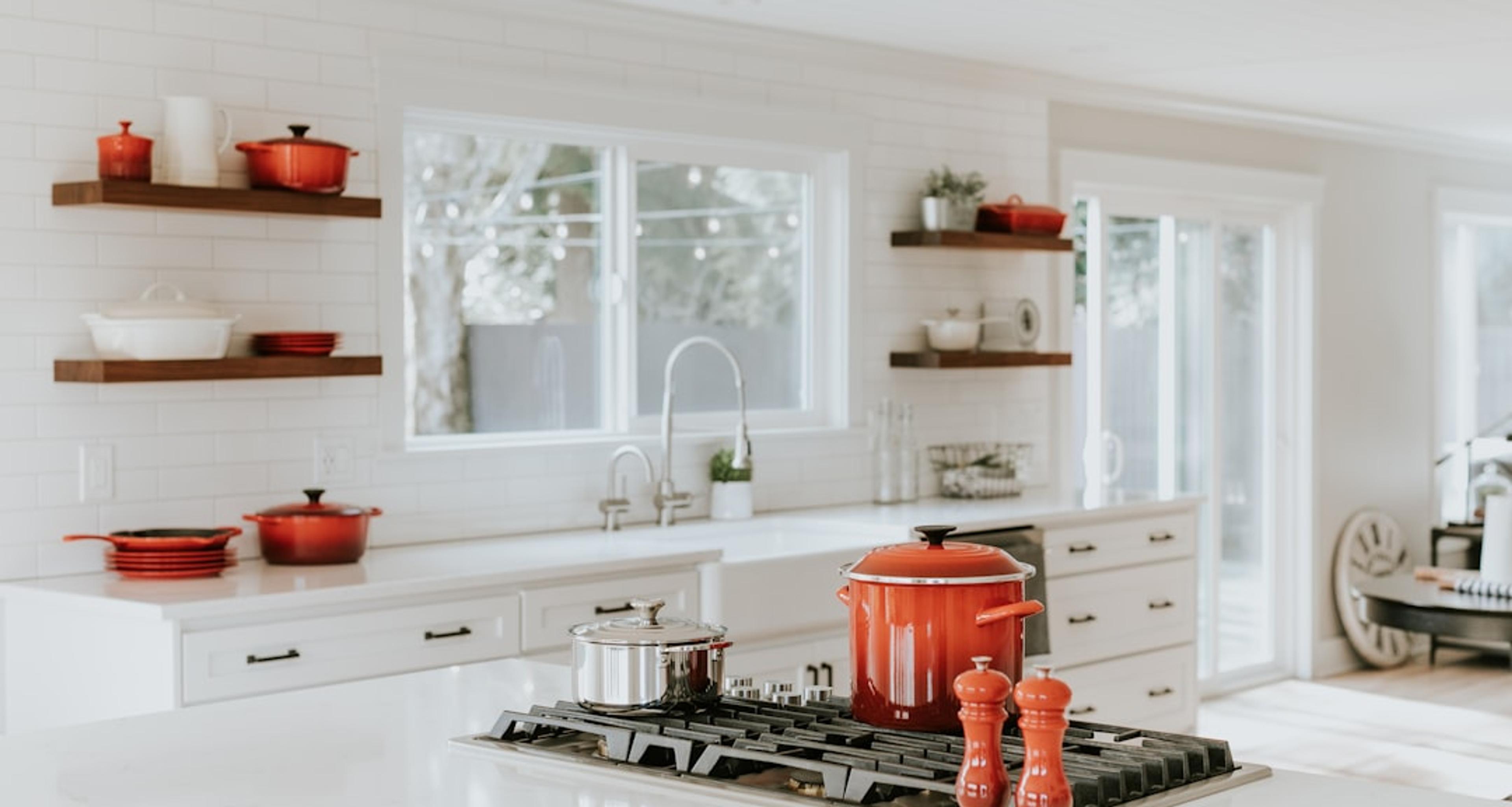 Styled open shelving with premium cookware in a white kitchen